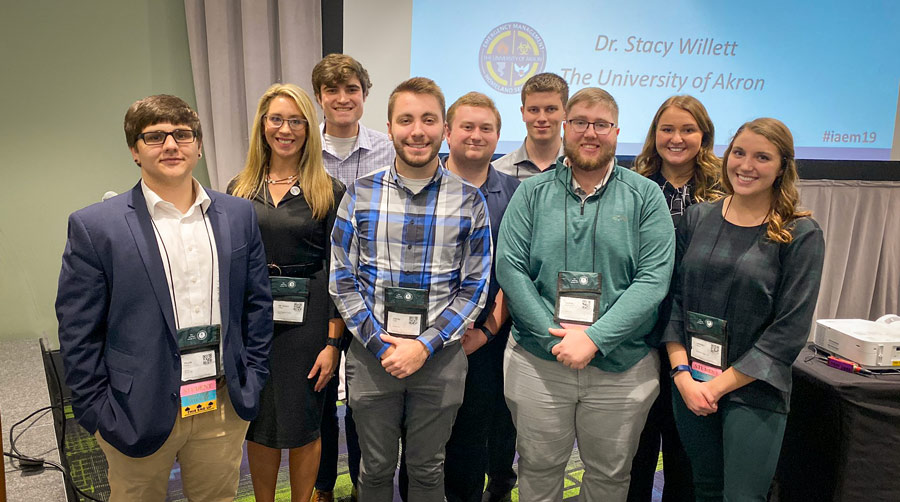 A professor stands with her emergency management students