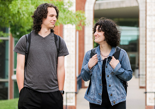 Two students walking across campus