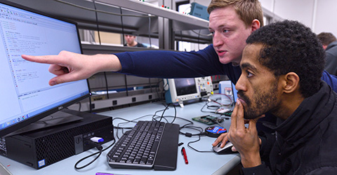Two engineering students at work in an engineering lab