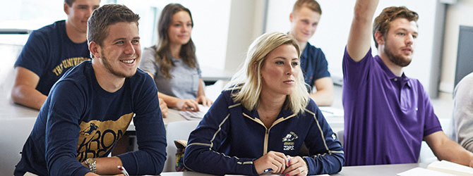 A group of students with their professor at a conference