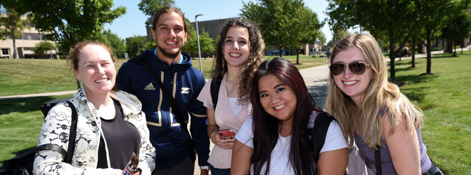 Students walk by the modern student union on a sunny summer day