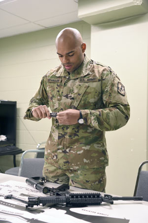 Cadet demonstrates the proper way to safely disassemble and maintain a rifle