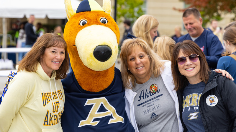 Parents of college students standing together at homecoming and family weekend.