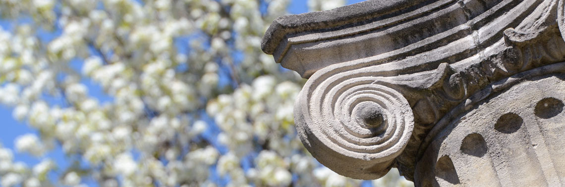 Decorative columns against a blue sky near the Arts & Sciences Building