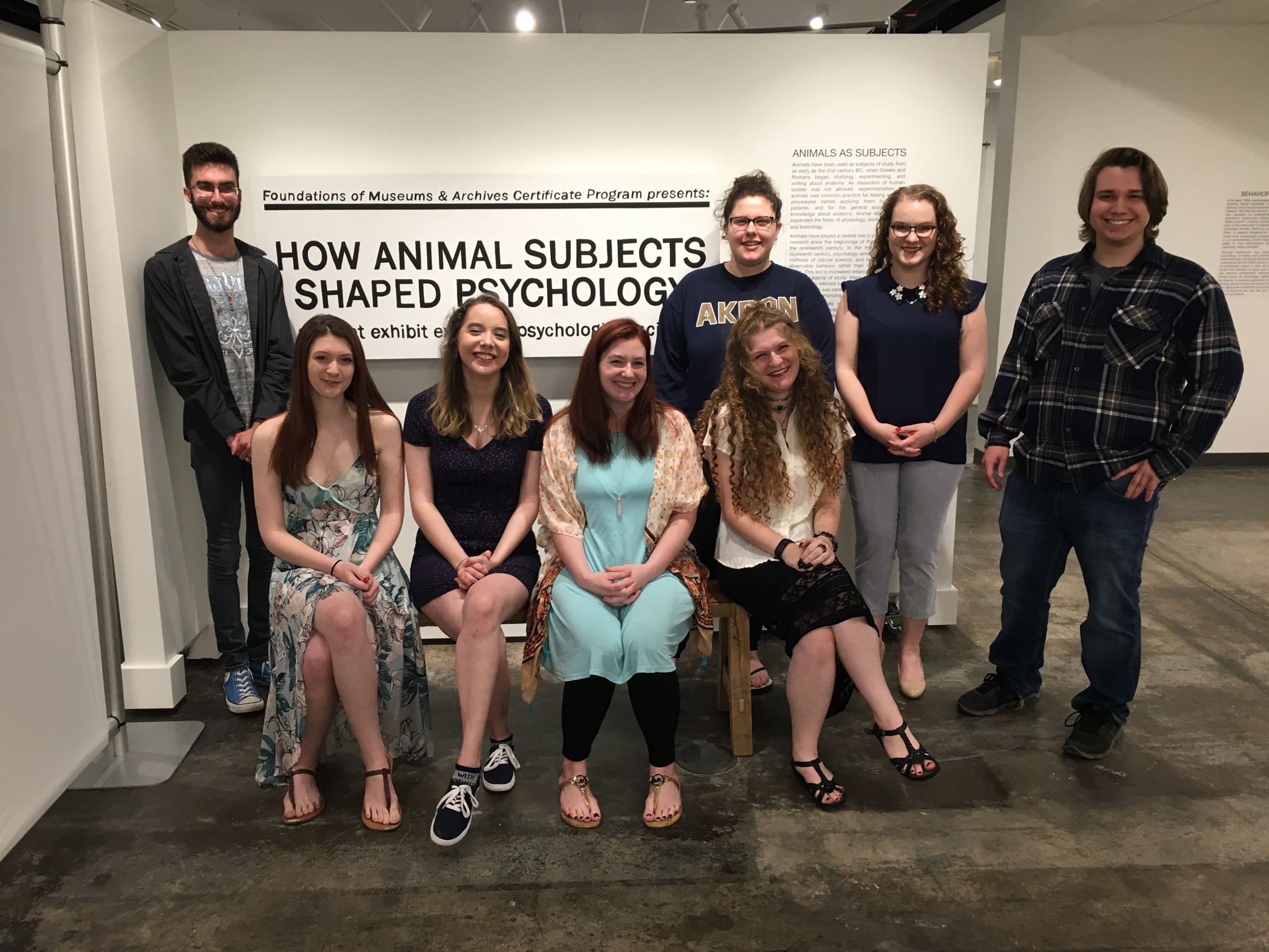Eight students from the certificate program posing in front of their completed exhibit