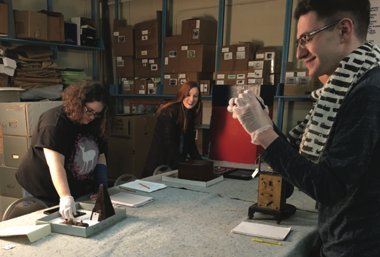 Students working with artifacts around a table