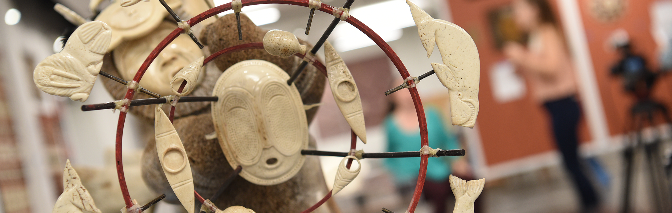 A bone-carved figure in a gallery setting