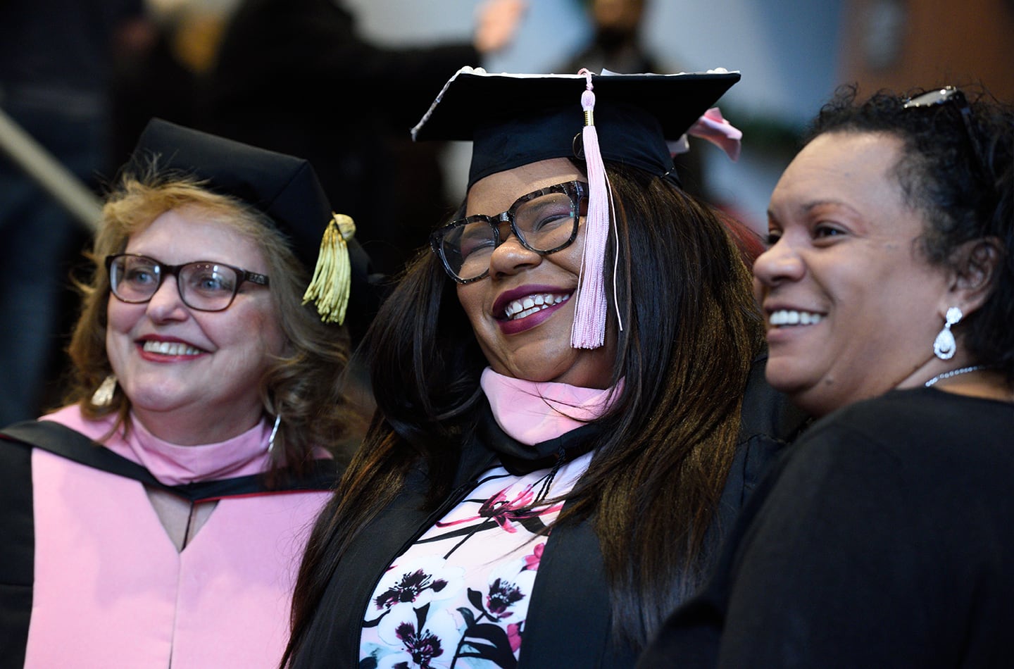 A smiling graduate with family by her side