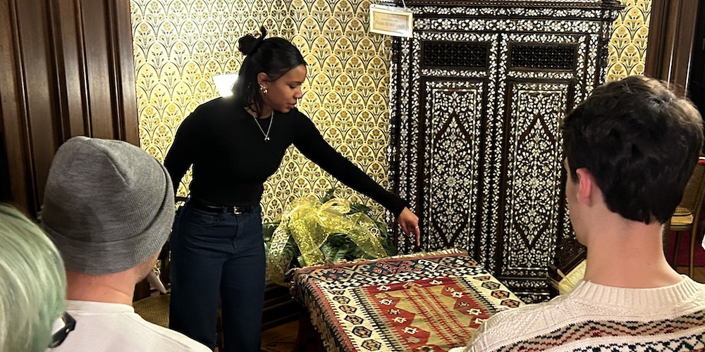 Student leads tour of Hower House and describes Turkish rug to audience.