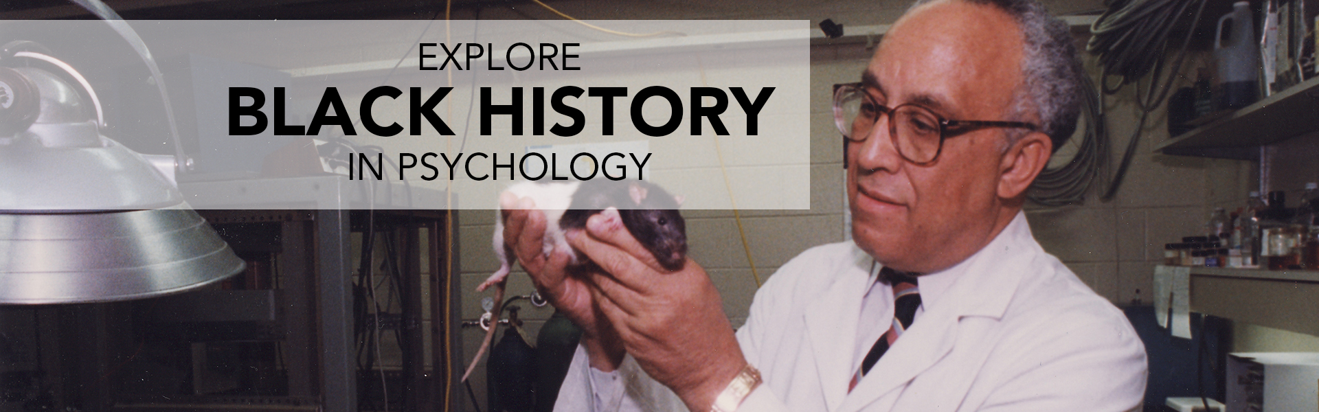 An African American man in a lab coat holding a lab rat with both hands. Text reads Explore Black History in Psychology