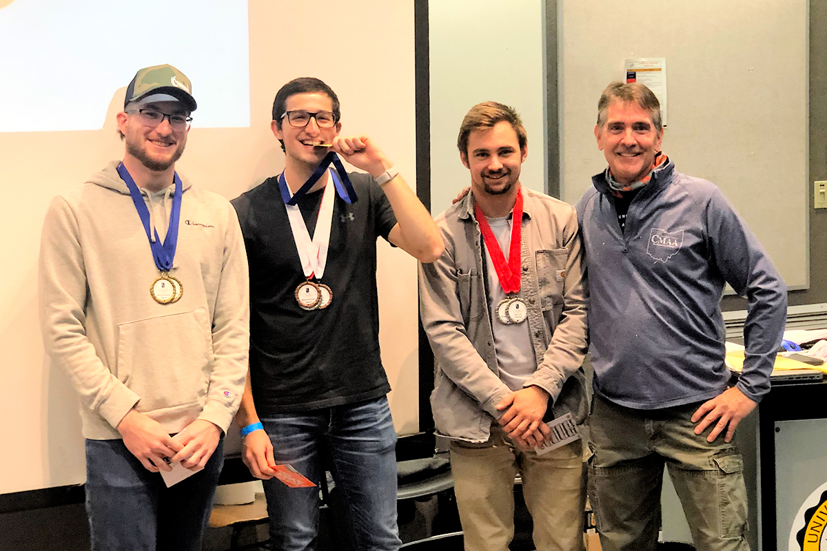 Jackson Iamarino (Second Place Winner), Andre Hineman (First Place Winner), Shane Larkins (Third Place Winner), with Brian Ballou, Professor of Construction Engineering Technology and the organizer of the Construction Olympics.