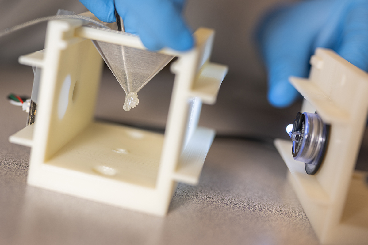 A detailed photo featuring the 3D-printed cochlear model with the insertion of a CI electrode.