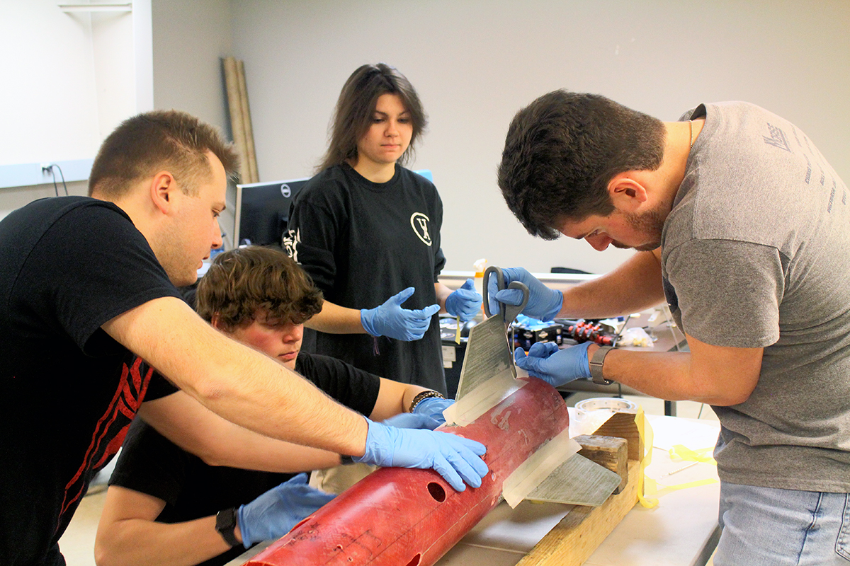 Pictured left to right are Akronauts members Lukas Seggi, Aidan St Clair, Emily Spinelli and Eric Diffendal working on the composite layup.