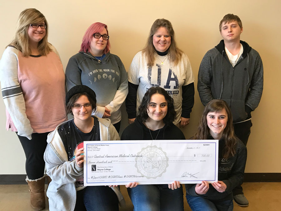 group posing with fundraising check