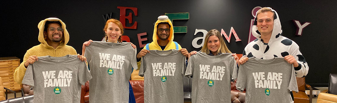 For I-Promise School students and aides hold T-shirts that say We Are Family