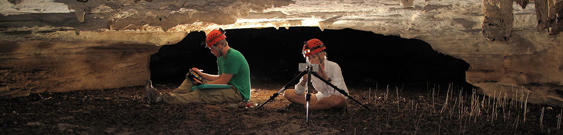 Two geosciences undergraduate students in a cave conducting research