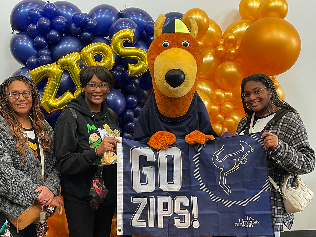 Family standing with Zippy in front of New Roo Experience sign.