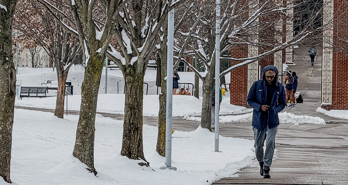 Winter photo of UA student walking on campus