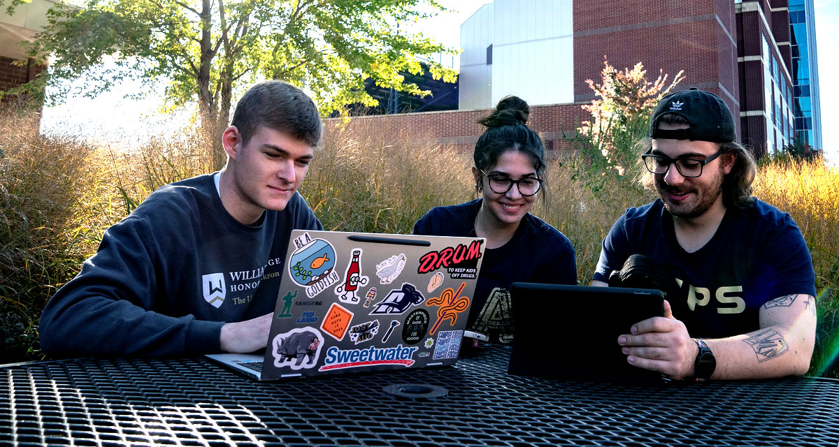 UA students seated outside with laptops