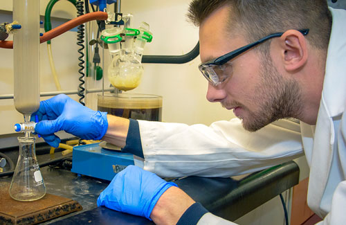 A student research conducts an experiment in a lab at UA