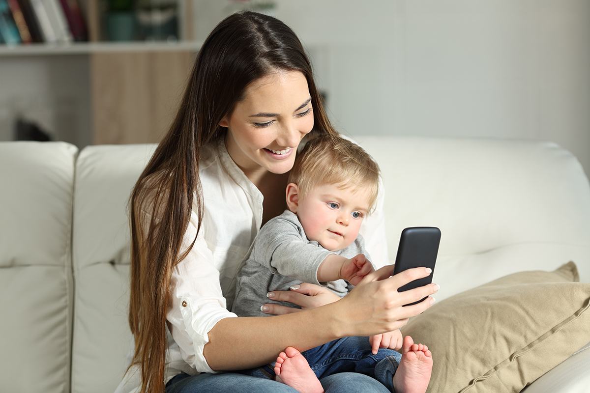 Mom holding baby and smartphone