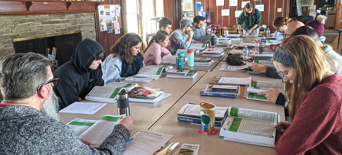 UA students at a table working on a curriculum