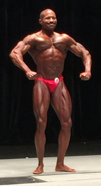 A bodybuilder on a stage holding a pose