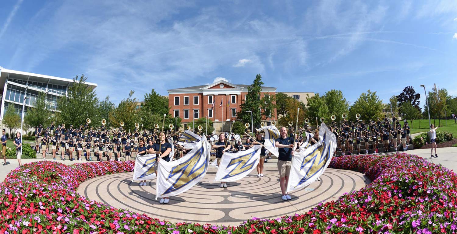 Two students discuss an English degree assignment outdoors between classes.
