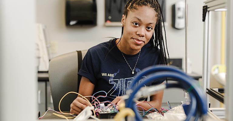 UA student in the engineering undergraduate program wires a circuit board.