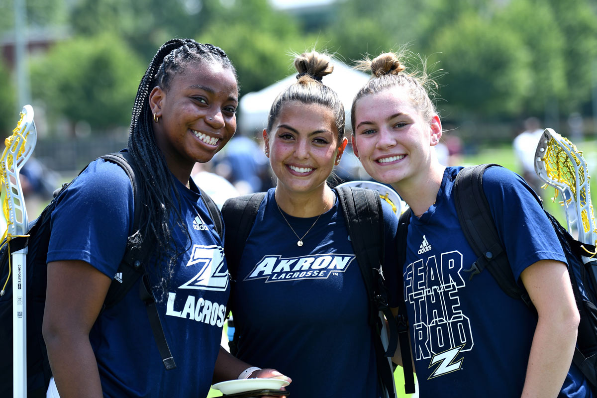 Three members of the lacrosse team stand for a photo