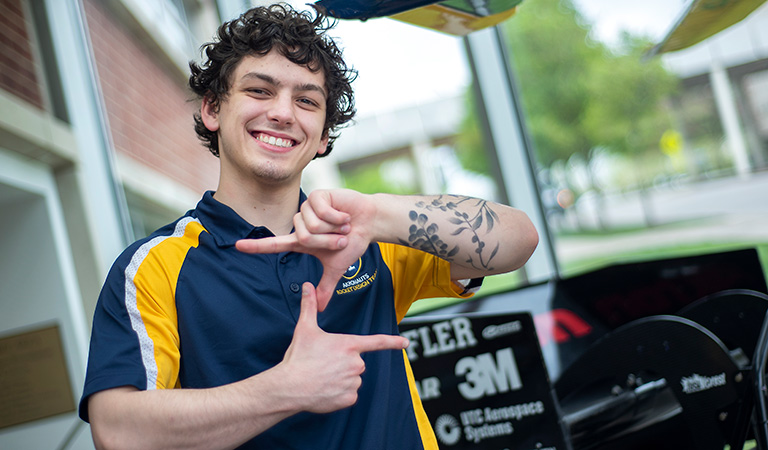 A Williams Honors College student makes a Z with his hands