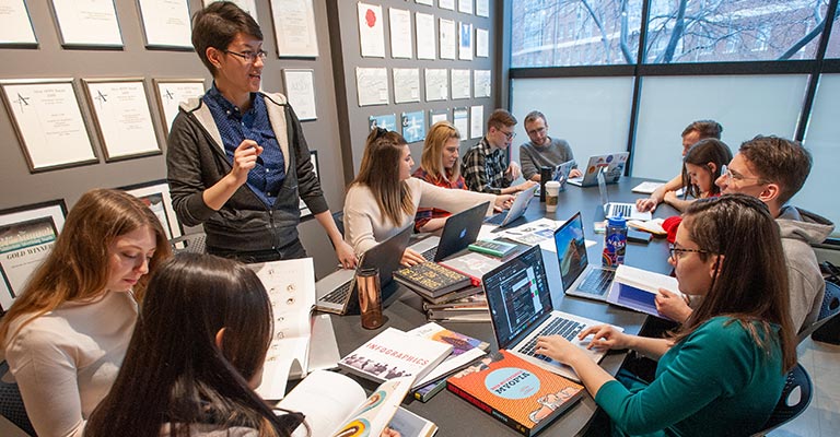 UA instructor and students sit at a conference table at the College of Arts & Sciences.