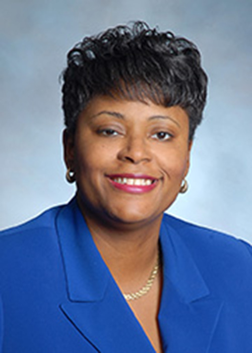 Headshot of woman smiling with blue top.