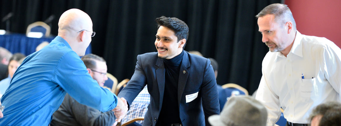 Two IP lawyers greet each other at a conference sponsored by Akron Law's top Intellectual Property Law Program