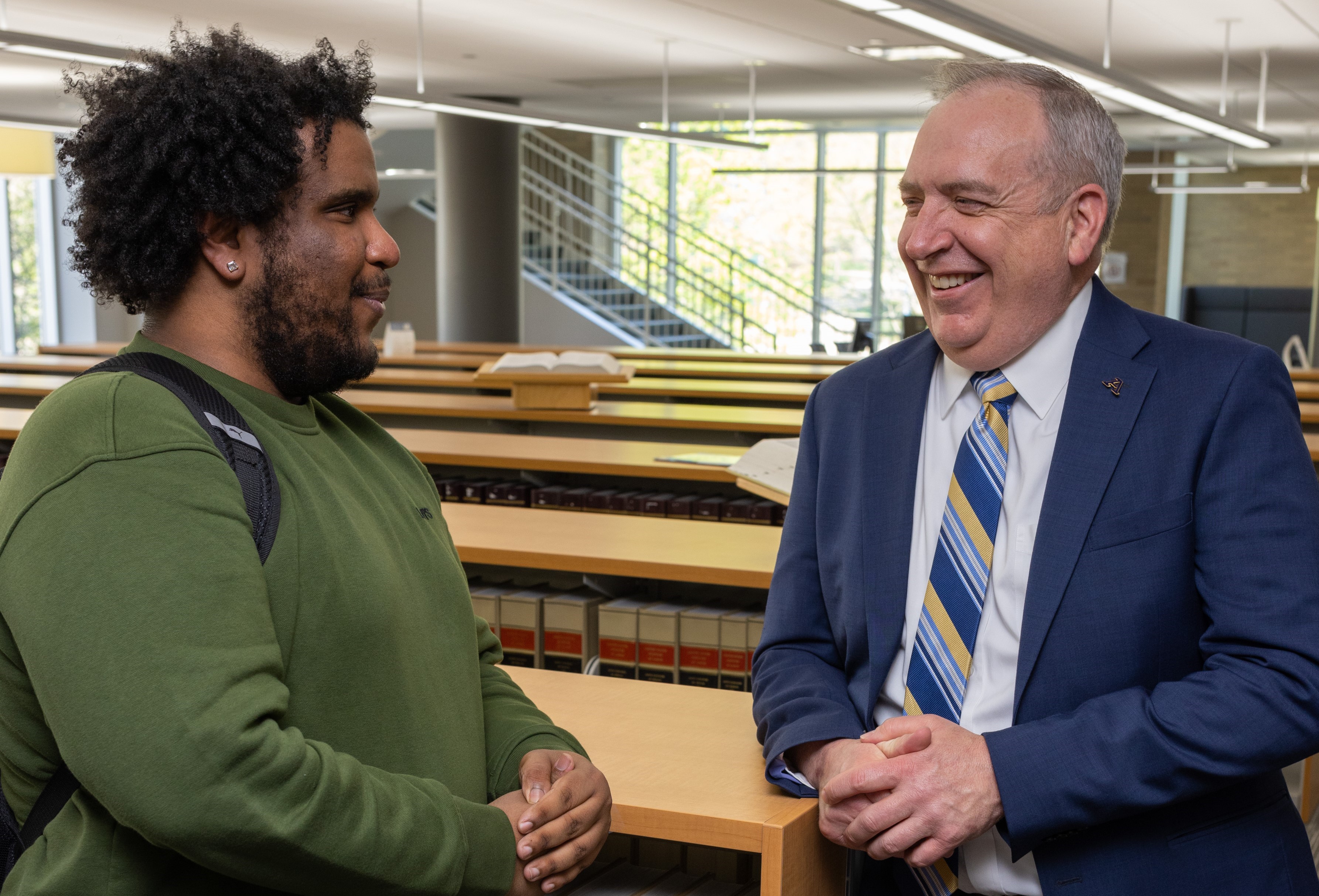 A member of the law faculty chats with a student in the school library