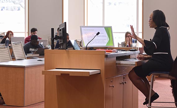 A faculty member makes a point during a class