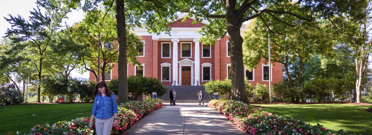 Students walk in front of Buchtel Hall, the main administration building on campus