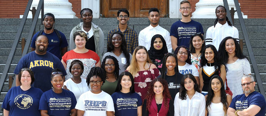 A group of peer mentors stand for a group photo on the steps of a campus building