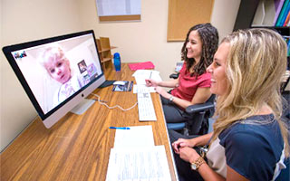 Students working online with a client in speech-language pathology lab