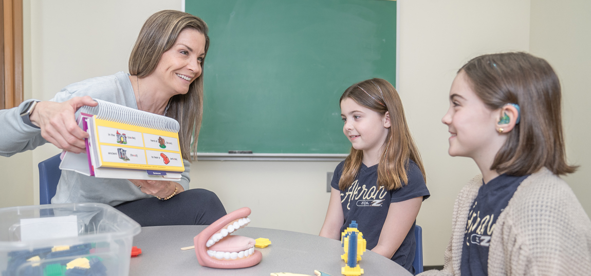 A graduate of the Speech Pathology and Audiology program working with a patient.