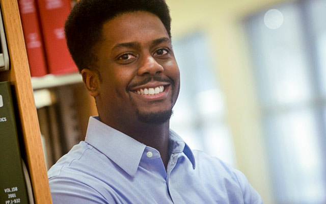 A communication professor talks with students in class