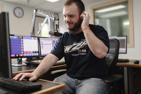 Two student announcers working in the UA WZIP radio studio during an on-air production.